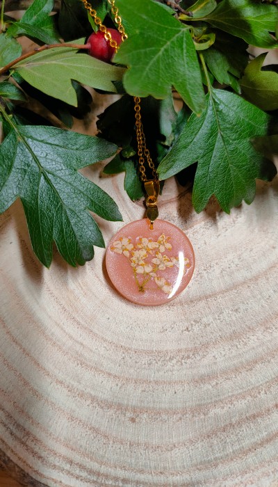 różowy naszyjnik z kwiatem bzu na drewnie