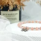 różowa bransoletka z kamieni ze srebrną kokardką ze stali szlachetnej